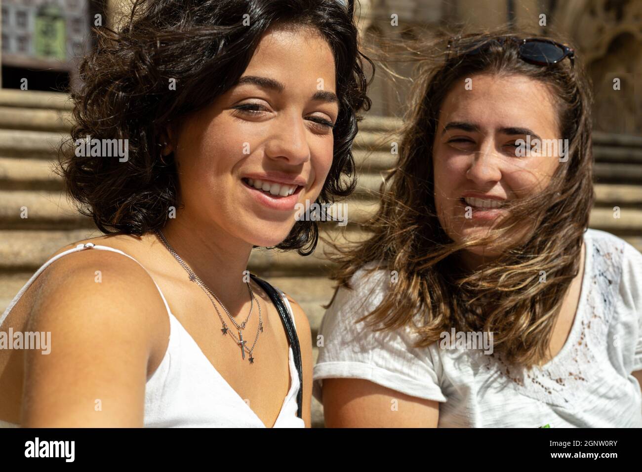 Détail d'une photo de selfie prise par deux jeunes femmes caucasiennes souriant à l'appareil photo tout en étant assis sur les escaliers Banque D'Images