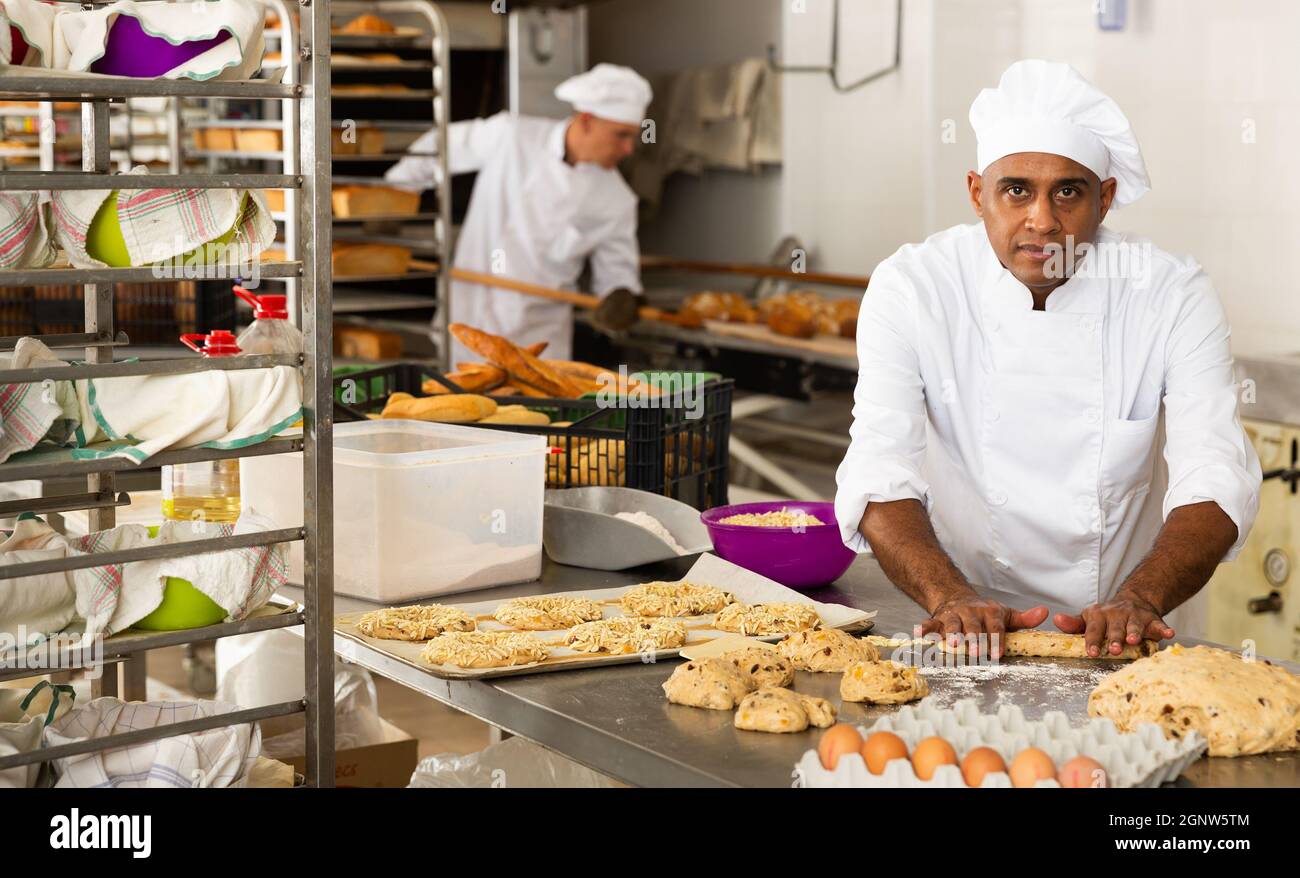 Boulanger masculin travaillant avec des baguettes formant de la pâte Banque D'Images