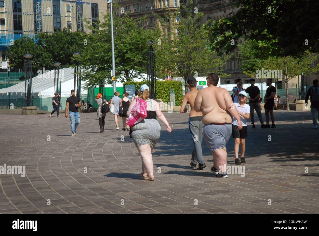 Jeune couple obèse marchant dans City Park, Bradford, Yorkshire, Angleterre. Banque D'Images