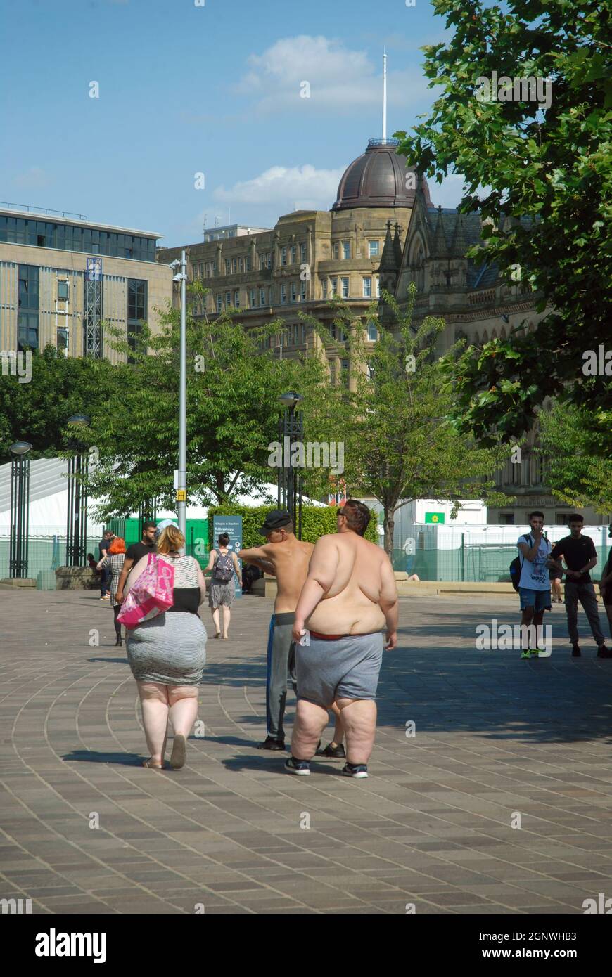 Jeune couple obèse marchant dans City Park, Bradford, Yorkshire, Angleterre. Banque D'Images