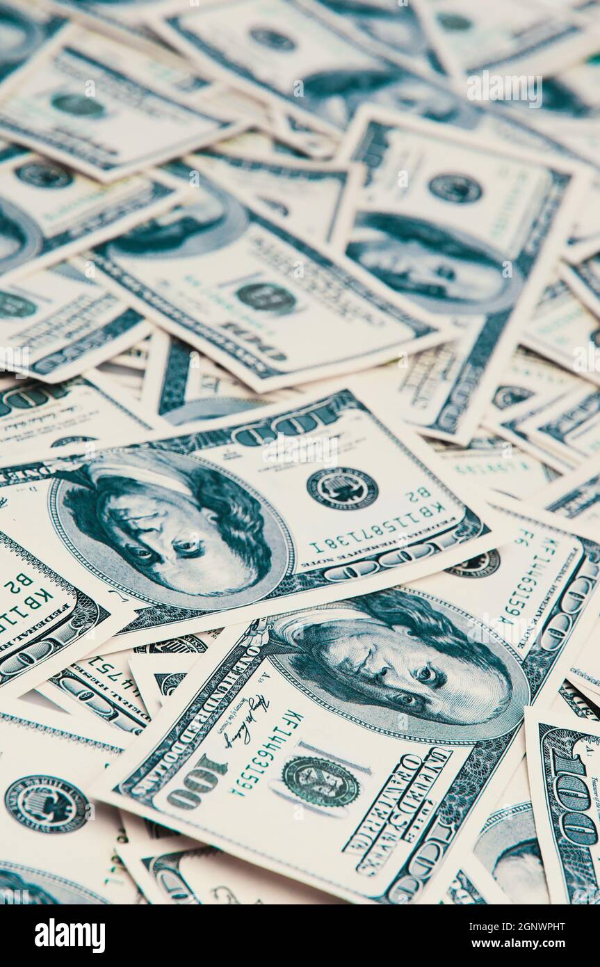 Une centaine de billets américains sont éparpillés. Billets de cent dollars en espèces, image de fond en dollars. Banque D'Images