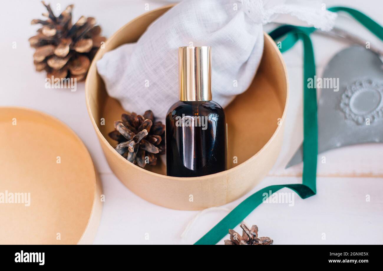Une maquette d'une bouteille en verre avec un produit cosmétique comme cadeau de Noël. Banque D'Images