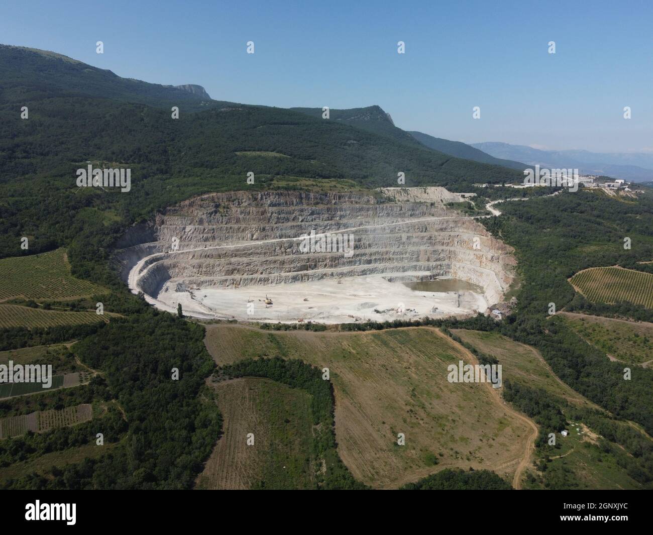 Vue aérienne industrielle d'une carrière d'exploitation minière en obât avec beaucoup de machines en travail - pierre concassée et matériaux de construction pour l'industrie de l'interprétation Banque D'Images