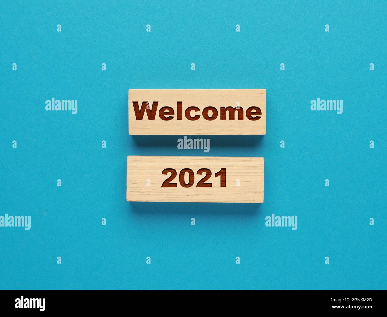 Deux blocs de bois avec l'inscription Welcome 2021 sur fond bleu, concept du nouvel an, Start the New Year, New Start. Banque D'Images