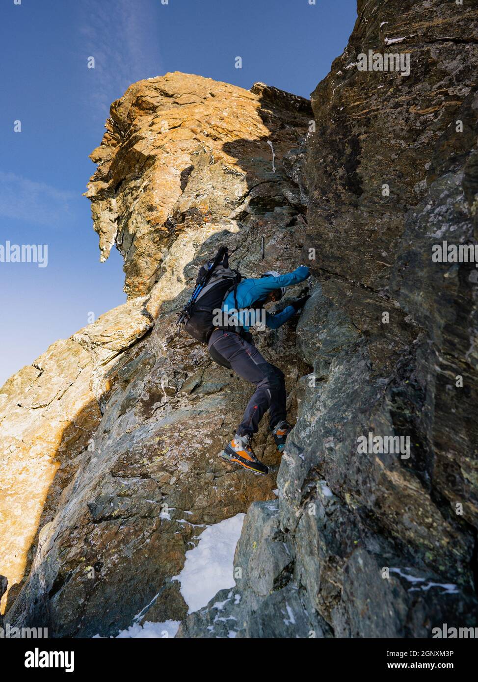 Vue arrière des grimpeurs avec sacs à dos à l'aide d'une corde fixe tout en montant haute montagne rocheuse. Hommes alpinistes escalade formation naturelle de roche Banque D'Images