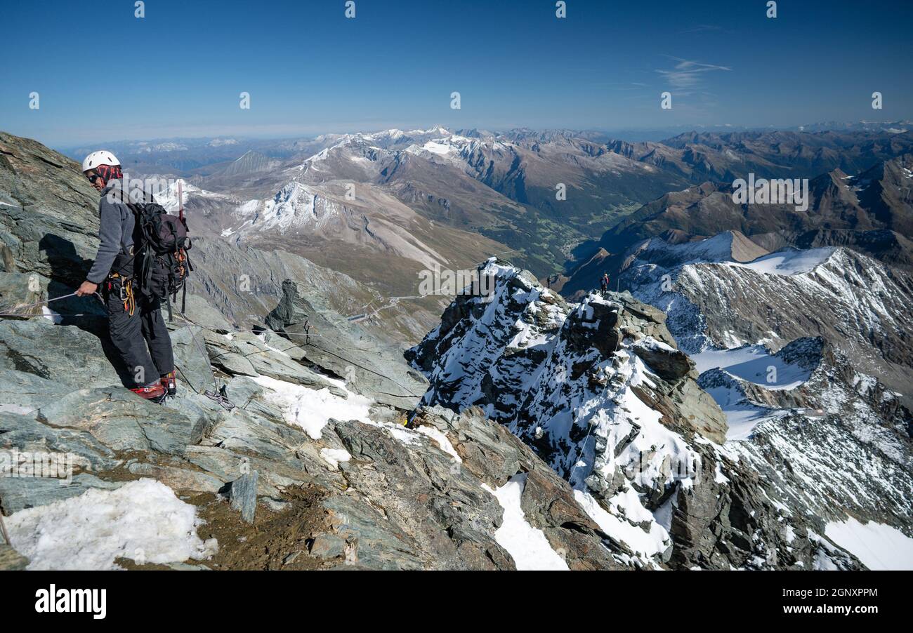 Homme dans les rochers. Escalade de la silhouette de randonnée dans les montagnes d'automne. Le grimpeur dans le paysage d'inspiration sur le sommet de montagne de Grossglockner le plus haut sommet de Banque D'Images