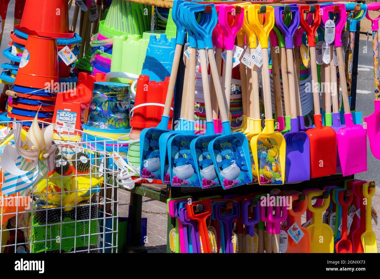 Seaux et bêches en plastique colorés et vibrants pour enfants ; jouets de plage en vente au bord de la mer au Royaume-Uni. Banque D'Images