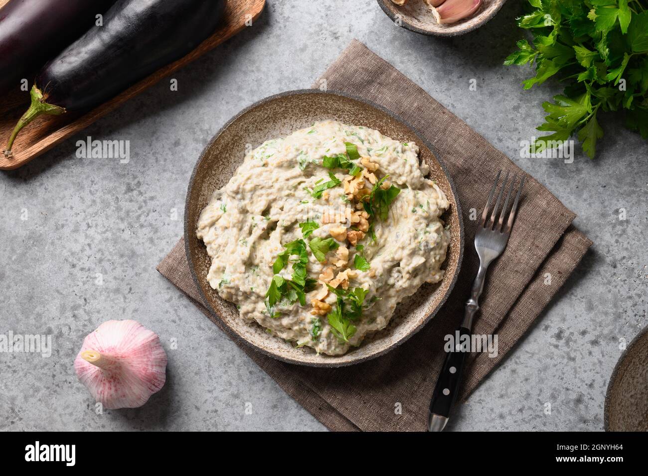 Baba ganoush apéritif à base d'aubergines cuites au four avec persil frais,  noix, ail et huile d'olive sur fond gris. Cuisine arabe et libanaise. Vue  avant Photo Stock - Alamy