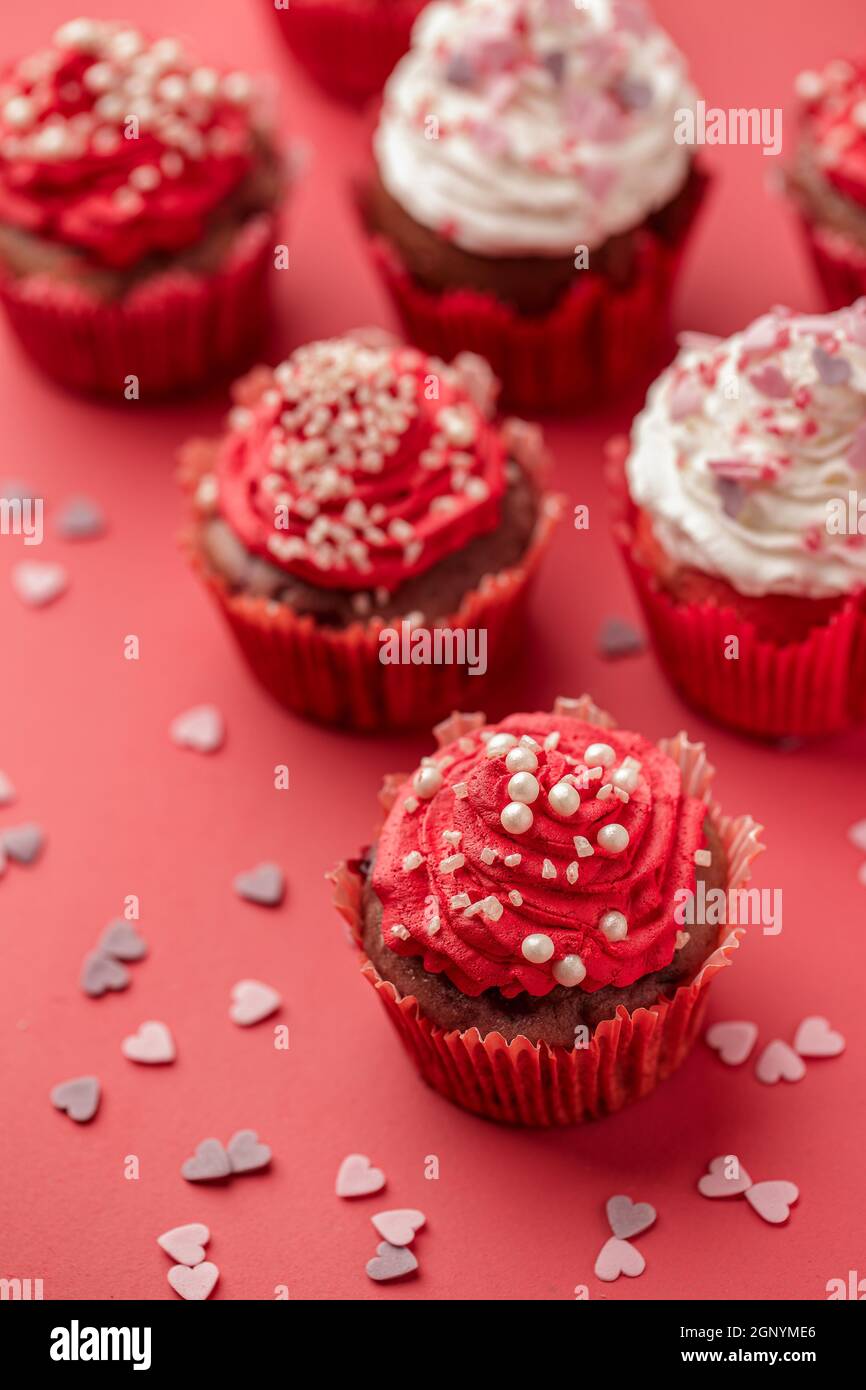 Cupcake à la crème et saupoudrer le sucre. Beau et délicieux cupcake sur fond rouge. Banque D'Images