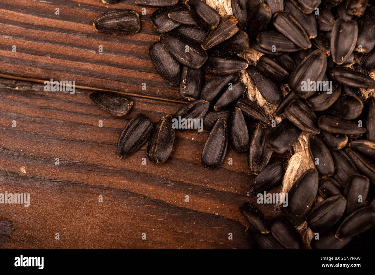 Graines de tournesol noires frites éparpillées sur la table, gros plan, mise au point sélective Banque D'Images