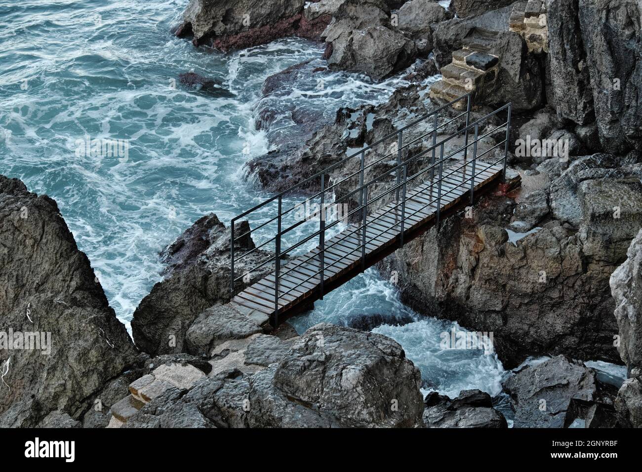 côte rocheuse de la Sicile, dans le petit pont de Cefalù sur les rochers de lave touchés par la mer agitée Banque D'Images