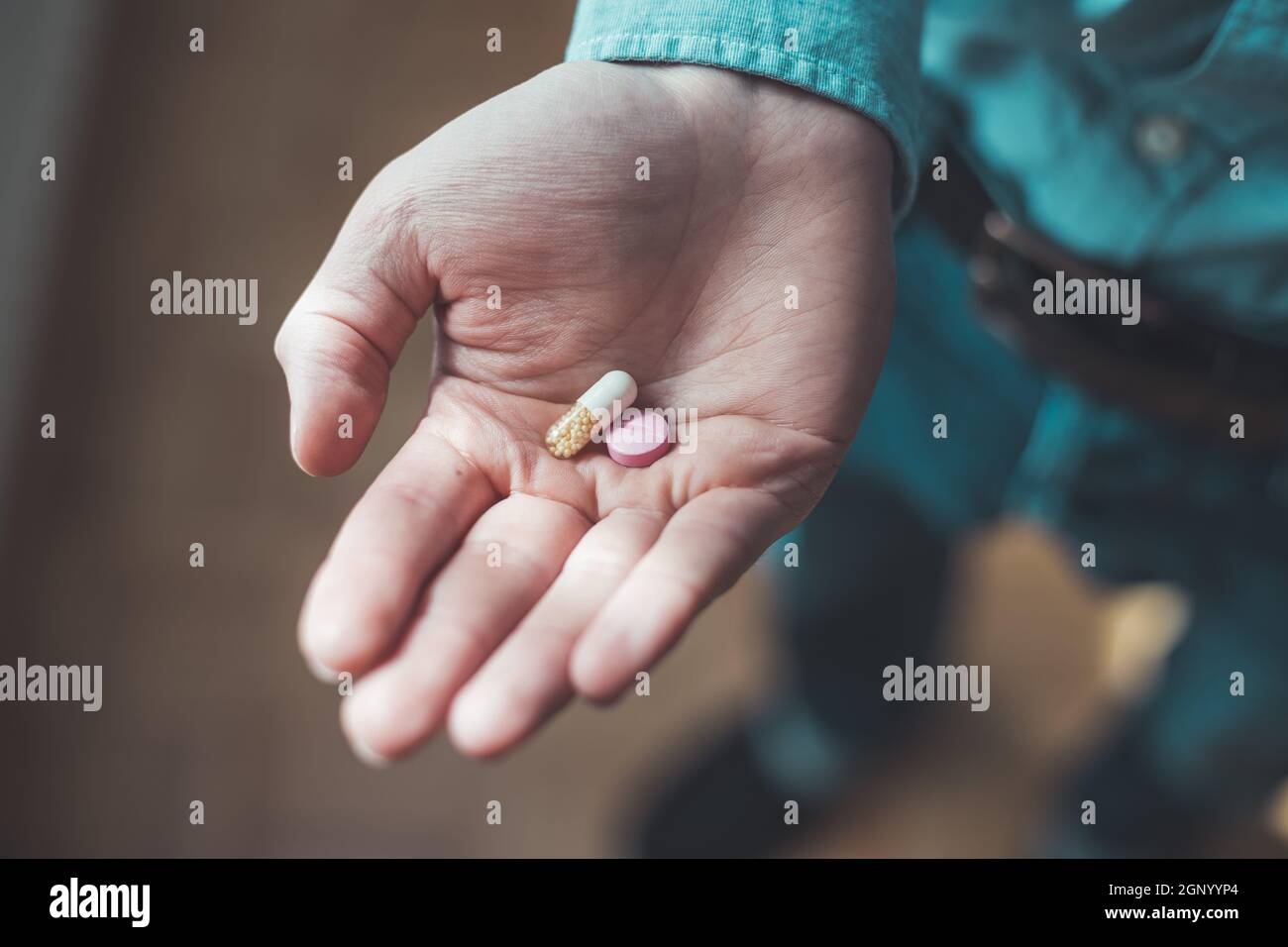 Main masculine tenant médicament ou vitamine comprimé dans Banque D'Images