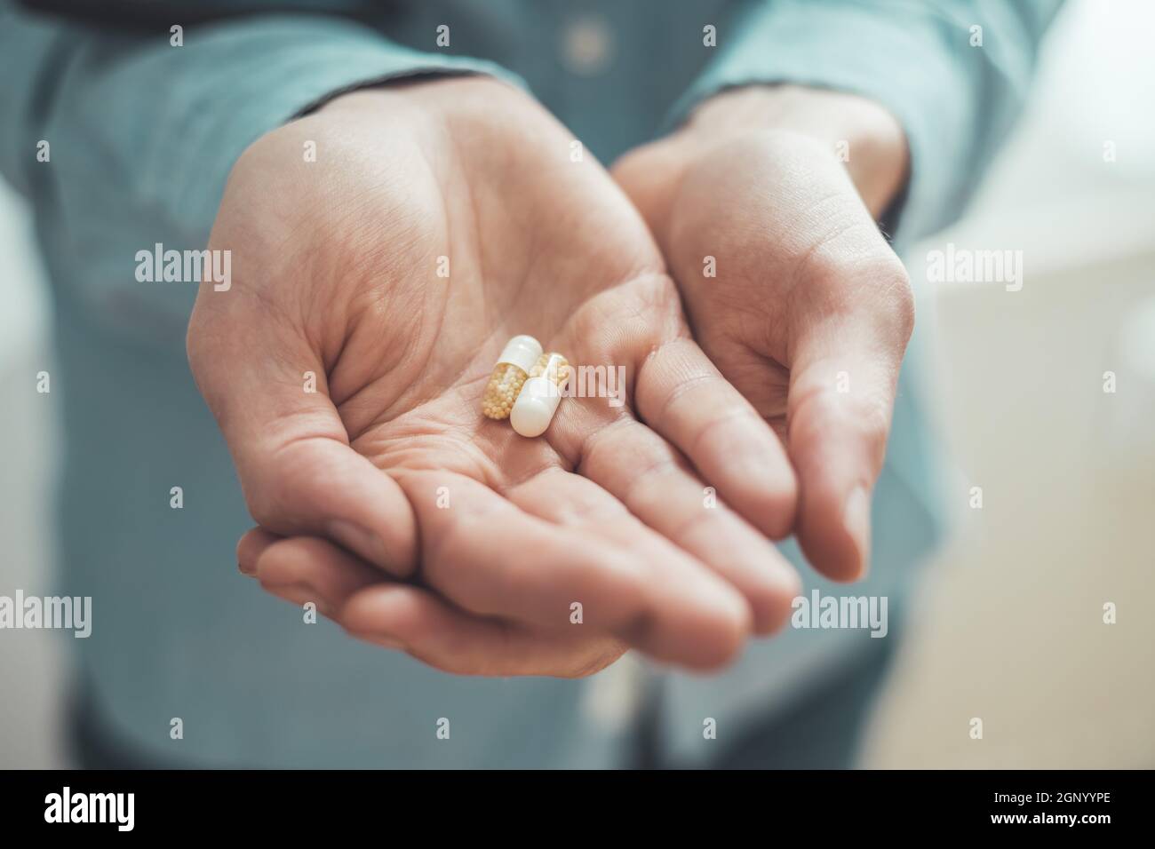 Main masculine tenant médicament ou vitamine comprimé dans Banque D'Images