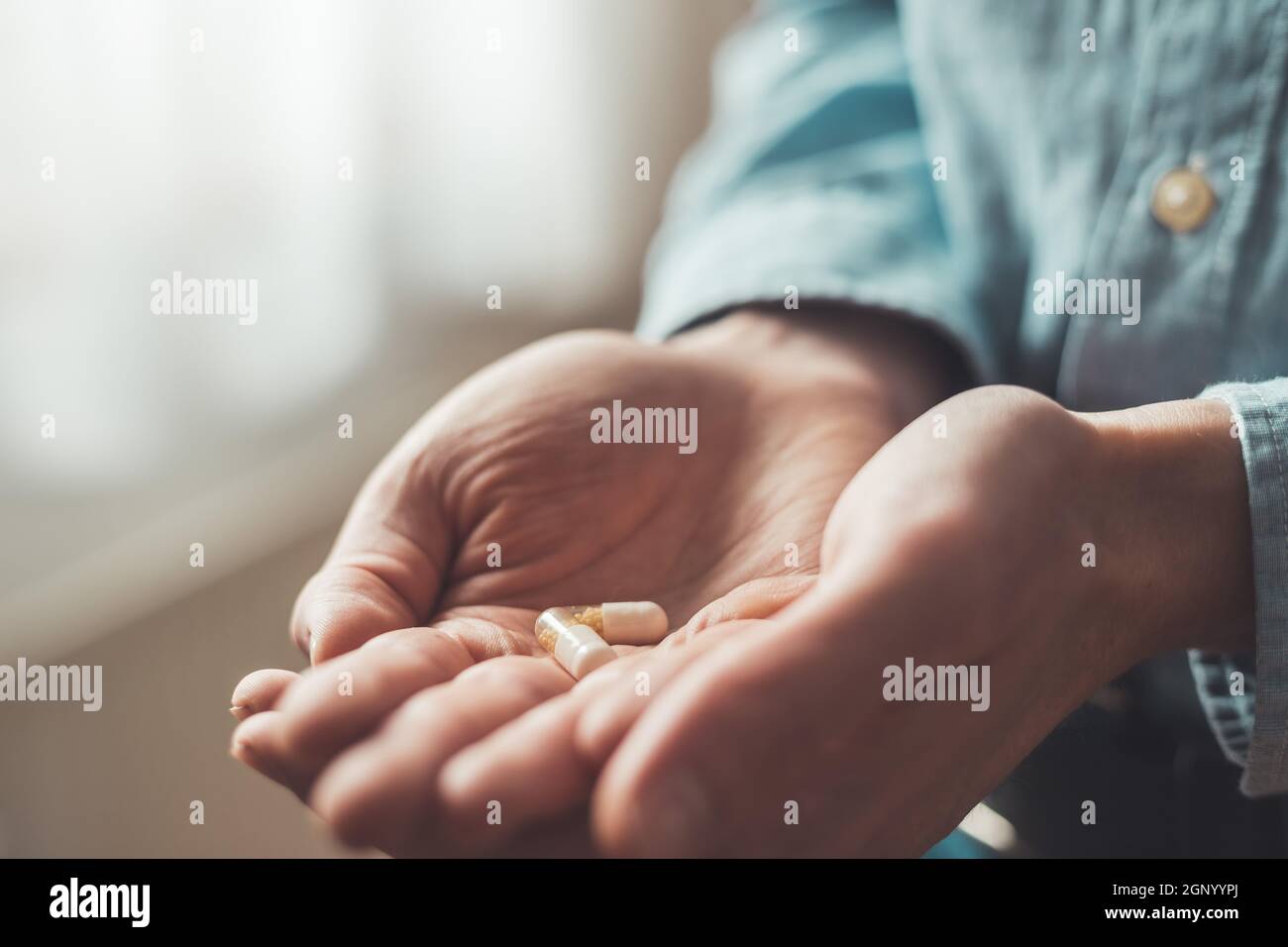 Main masculine tenant médicament ou vitamine comprimé dans Banque D'Images