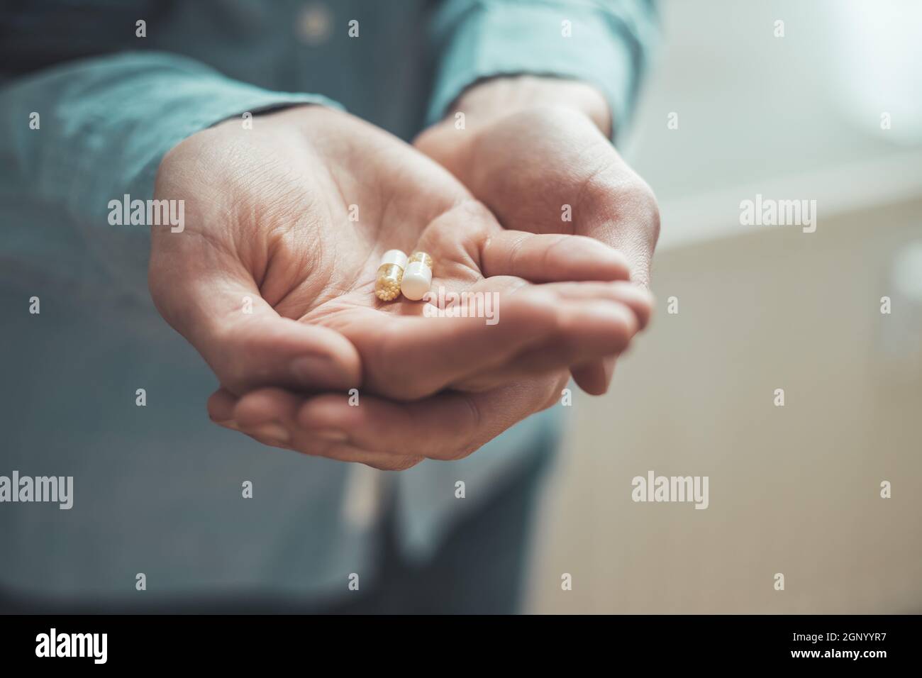 Main masculine tenant médicament ou vitamine comprimé dans Banque D'Images