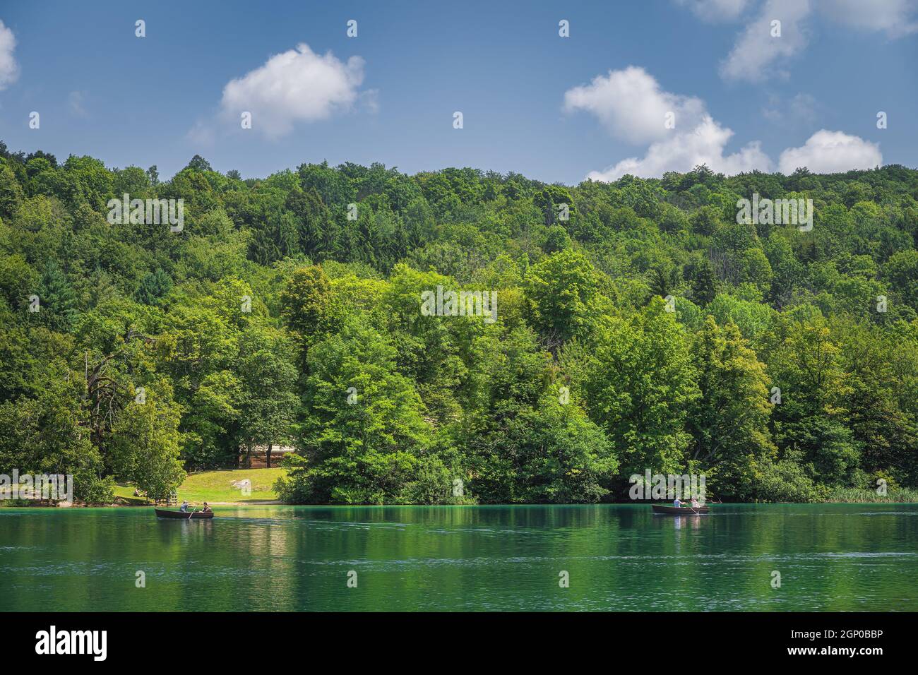 Les touristes pagayent dans deux bateaux sur le lac vert émeraude à Parc national des lacs de Plitvice Patrimoine mondial de l'UNESCO en Croatie Banque D'Images