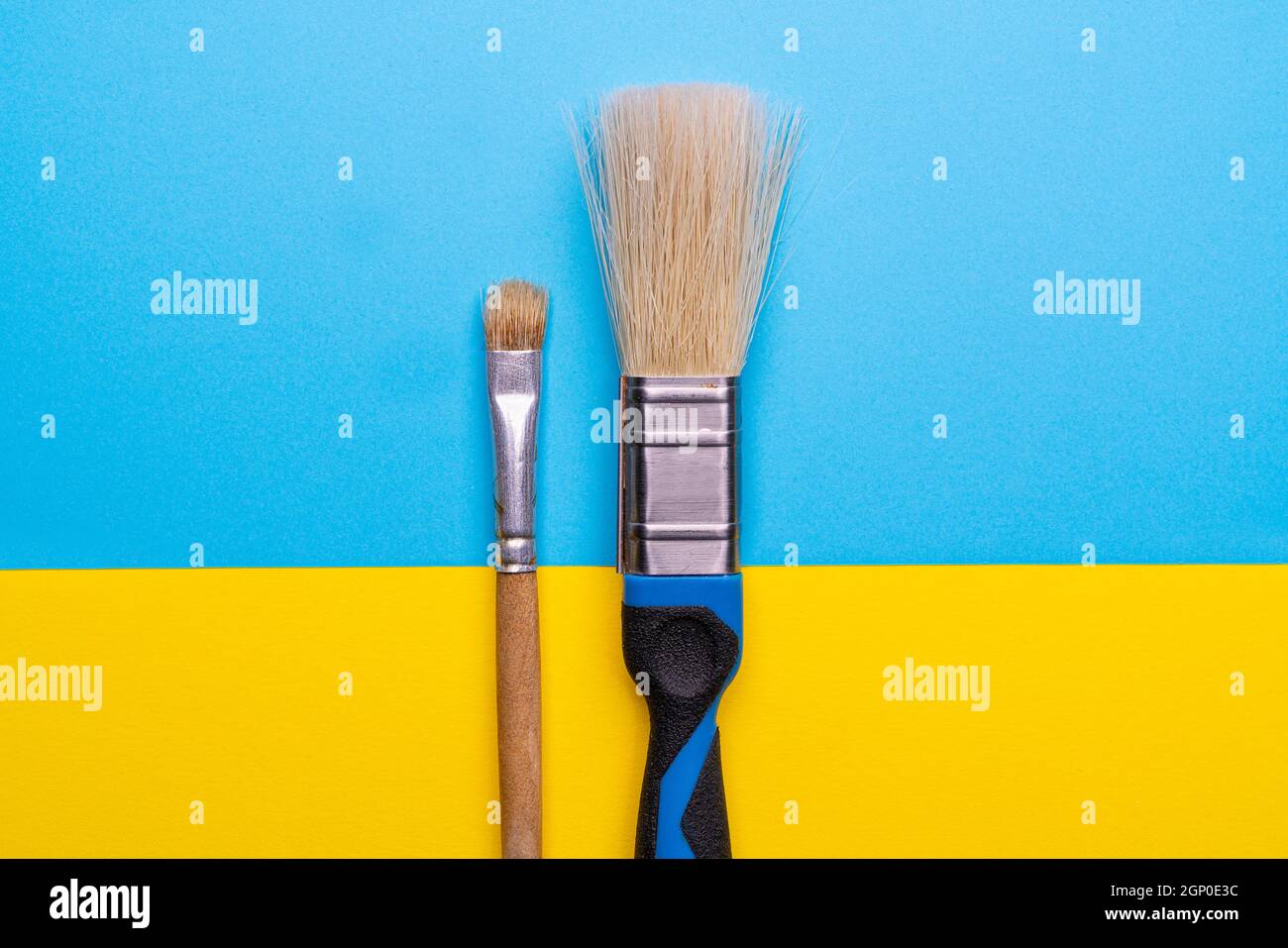 une grande et une petite brosse placées côte à côte sur une surface colorée Banque D'Images