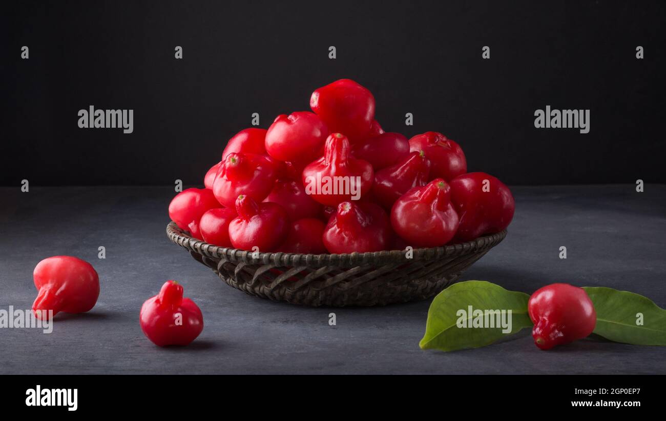 jambu ou pomme rose, fruits en forme de cloche également appelés fruits de cloche ou pomme de cire, fruits juteux sri lanka dans un panier, pris sur fond sombre Banque D'Images