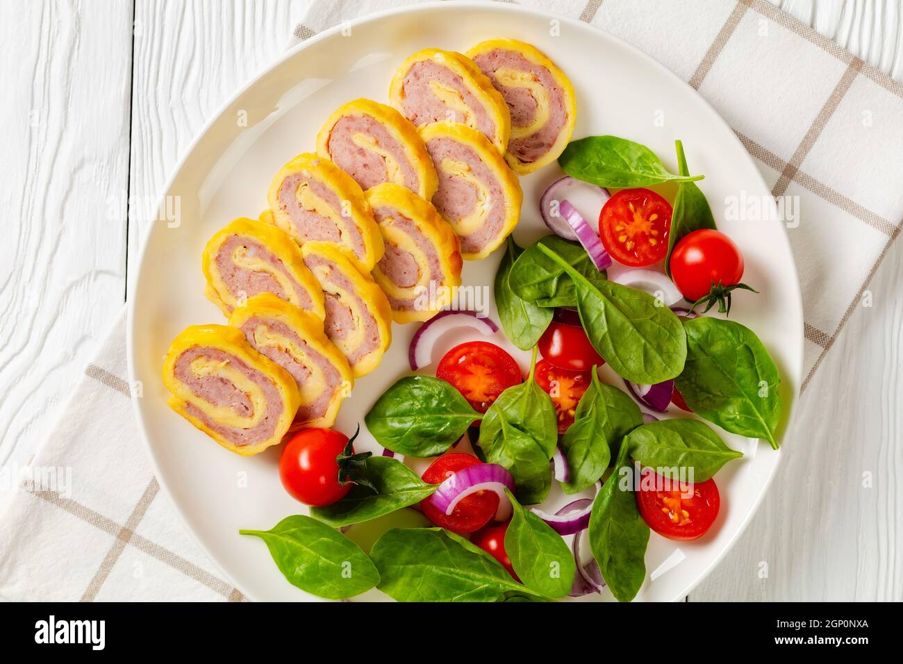 petit déjeuner au jambon et au fromage, omelettes et salade d'oignons rouges aux épinards frais sur une assiette sur une table en bois blanc, vue horizontale depuis le dessus, fl Banque D'Images