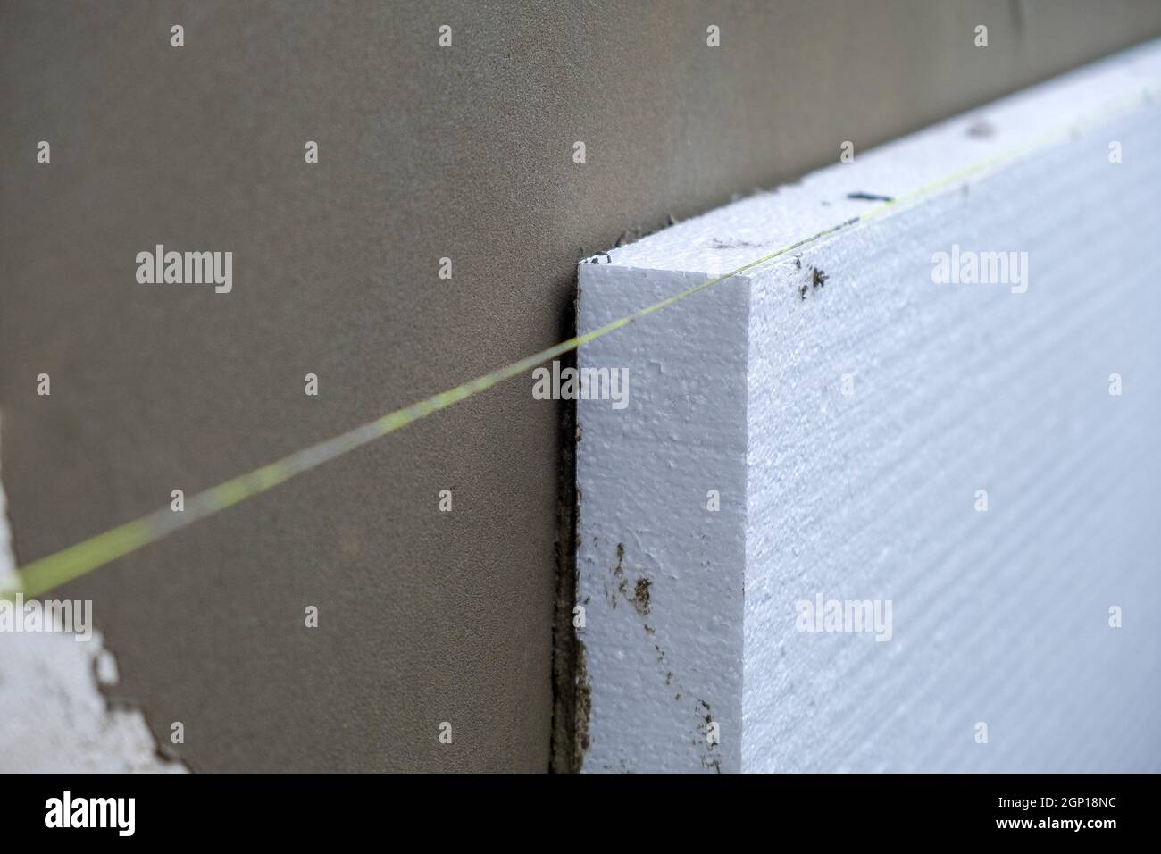 Installation de feuilles d'isolation en mousse de polystyrène sur le mur de la façade de la maison pour la protection thermique. Banque D'Images