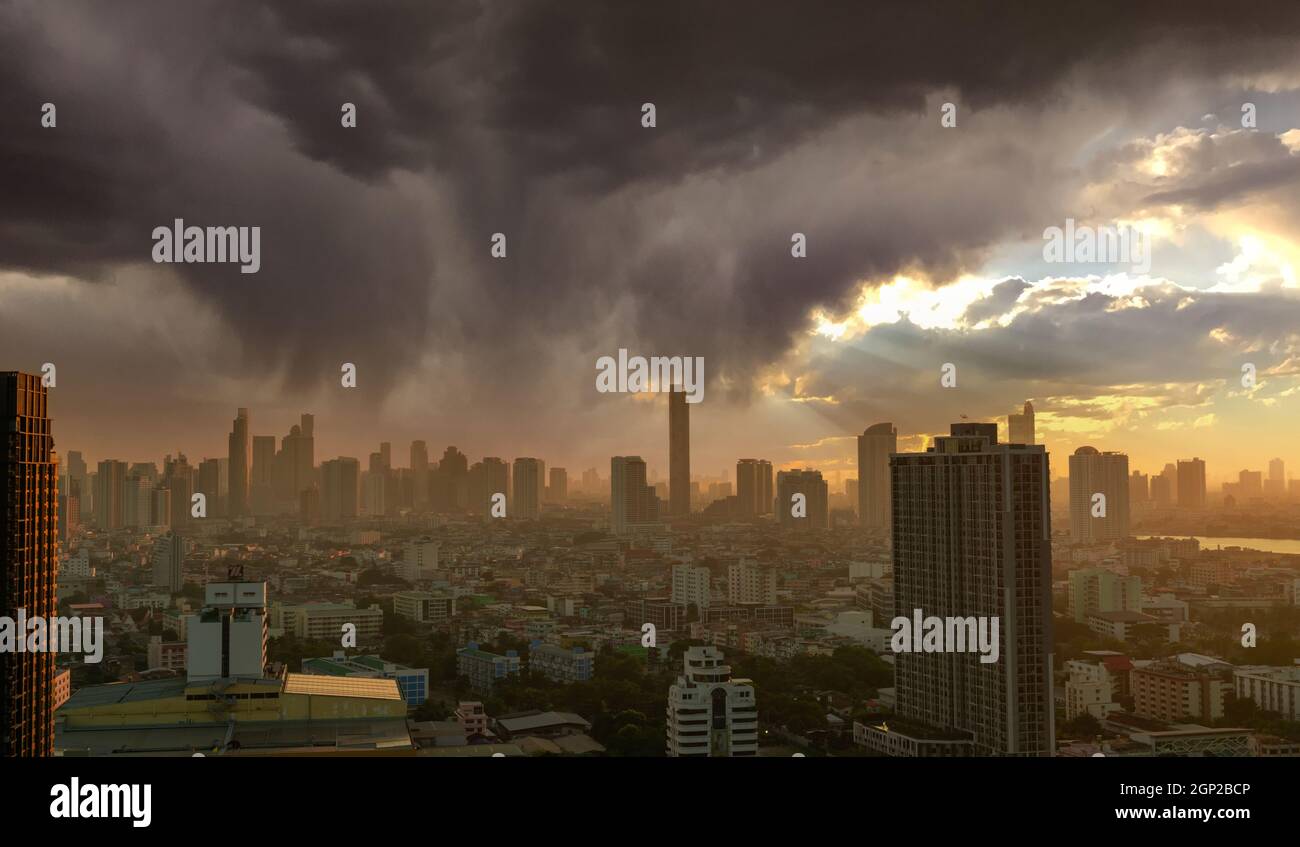 Paysage urbain avec gratte-ciel. Soleil du matin à travers le ciel avec des nuages gris. Ville au bord de la rivière avec un lever de soleil doré. Bâtiment urbain moderne. CRO Banque D'Images