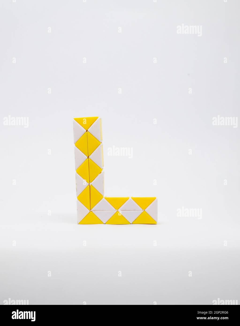 Lettre 'l' composée de triangles jaunes et blancs sur fond blanc. Banque D'Images