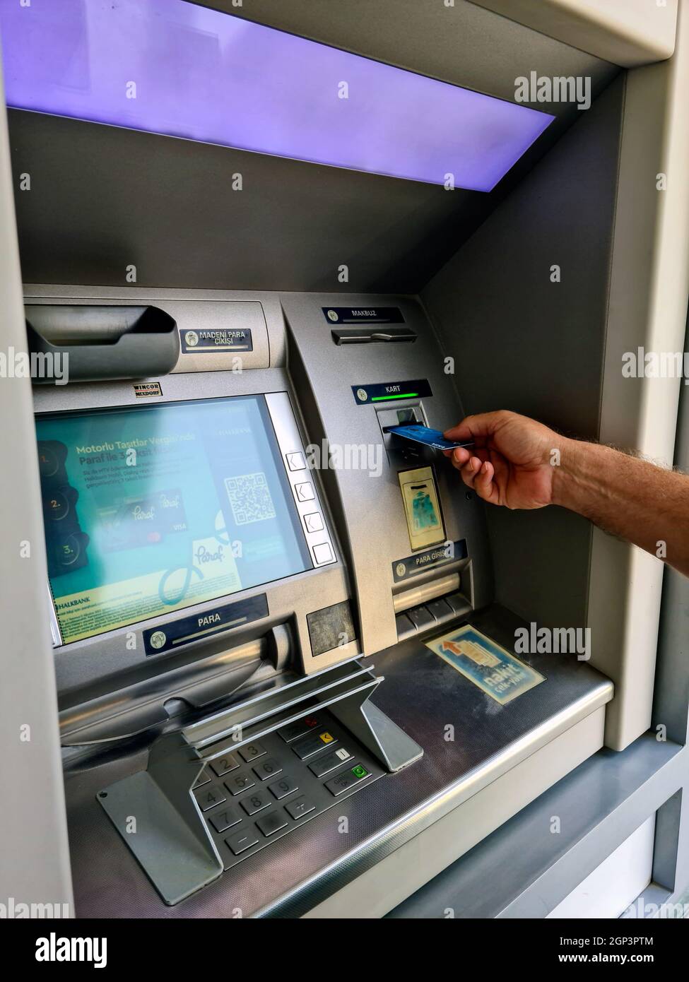 La main de l'homme retire son salaire du guichet automatique Banque D'Images