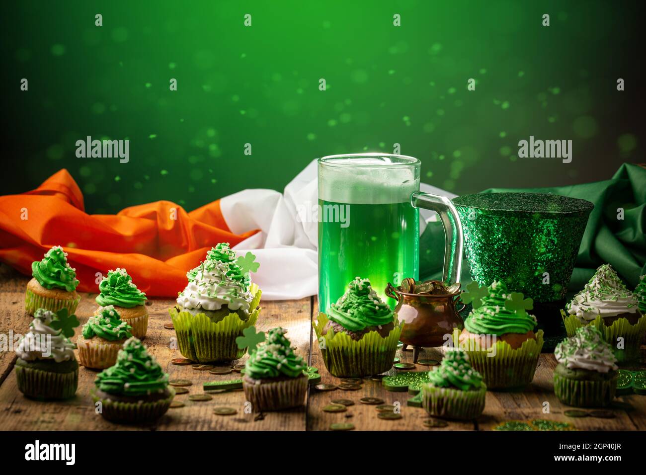 Bière traditionnelle verte froide et petits gâteaux avec chapeau Leprechaun et drapeau irlandais sur table en bois pour la Saint Patrick, espace de copie Banque D'Images