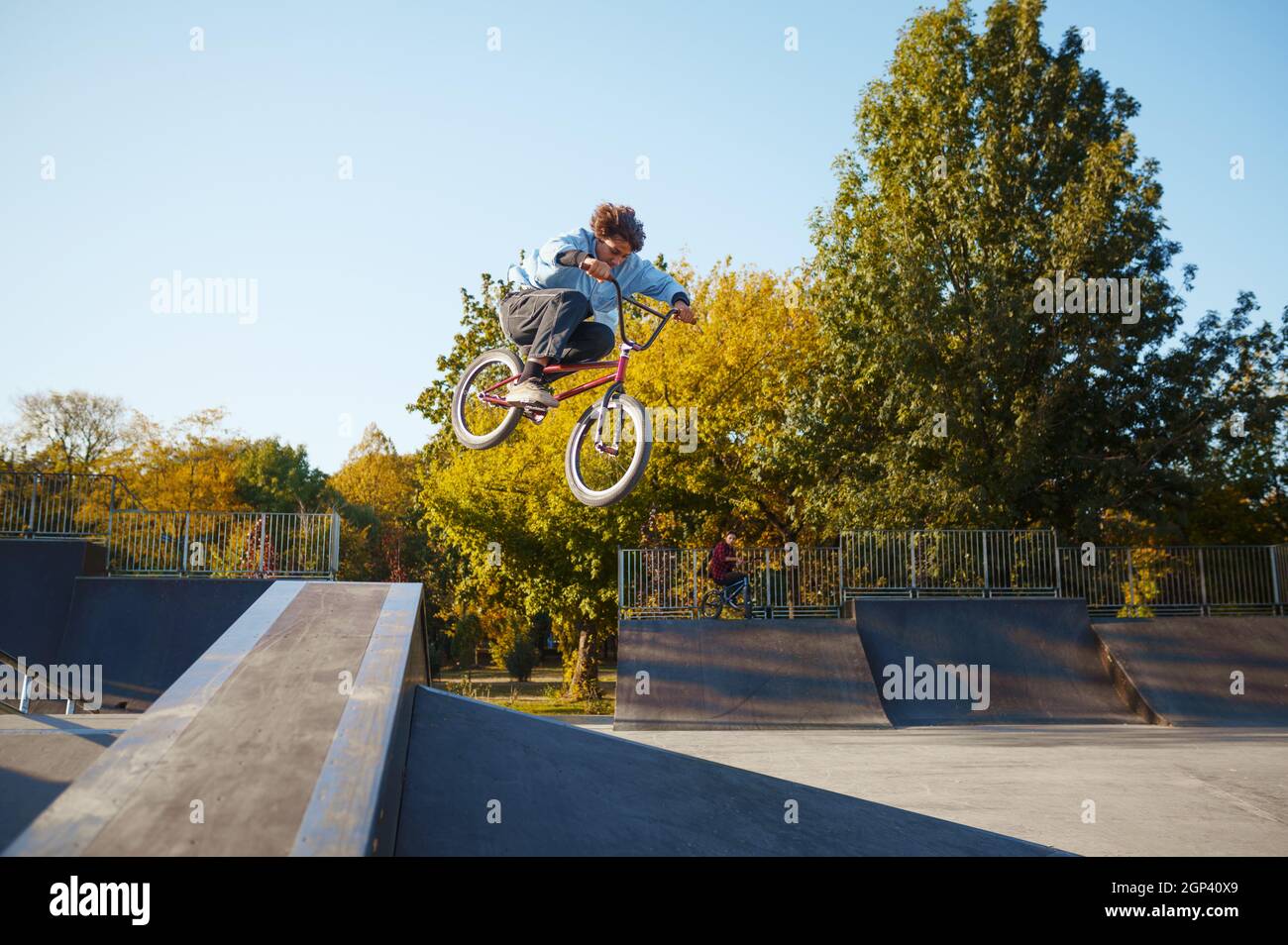 Un jeune cycliste bmx se déplace en balustrade dans un parc à roulettes. Sports extrêmes de vélo, tour de vélo dangereux, équitation dans la rue, vélo dans le parc d'été Banque D'Images