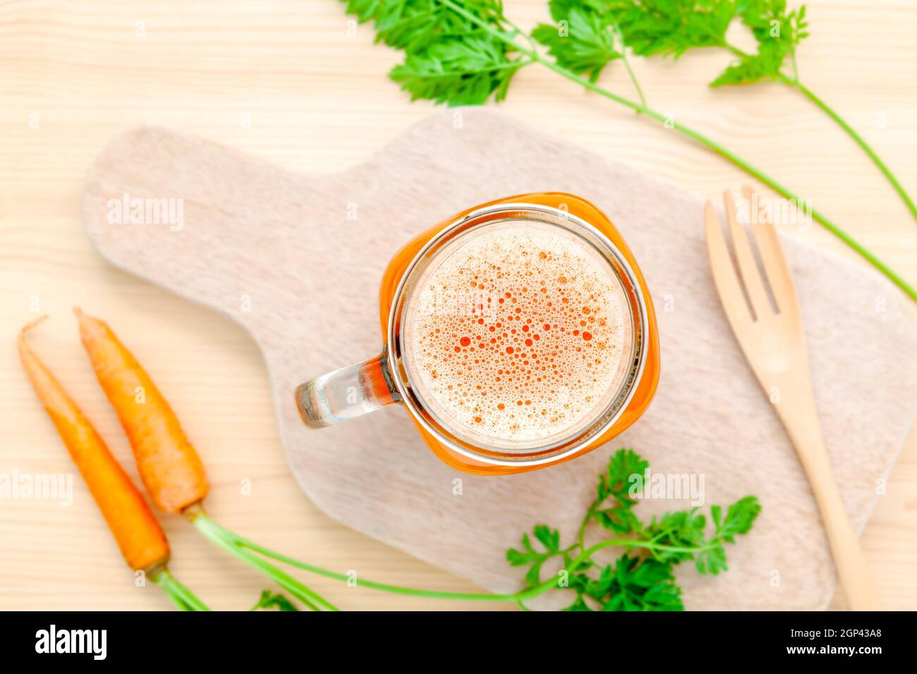 Verres de jus de carotte avec racines de carottes sur fond de bois.verres de jus de carotte frais savoureux.Jus de carotte et les carottes. Selective focus dept de f Banque D'Images