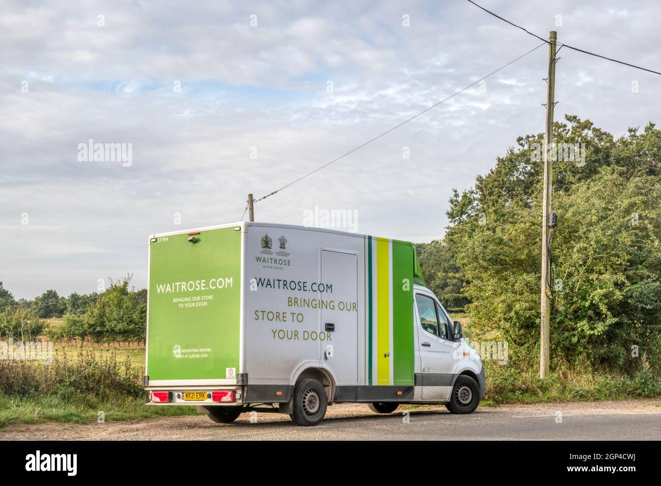 Une fourgonnette de livraison Waitrose garée sur une route de campagne tranquille à Norfolk. Banque D'Images