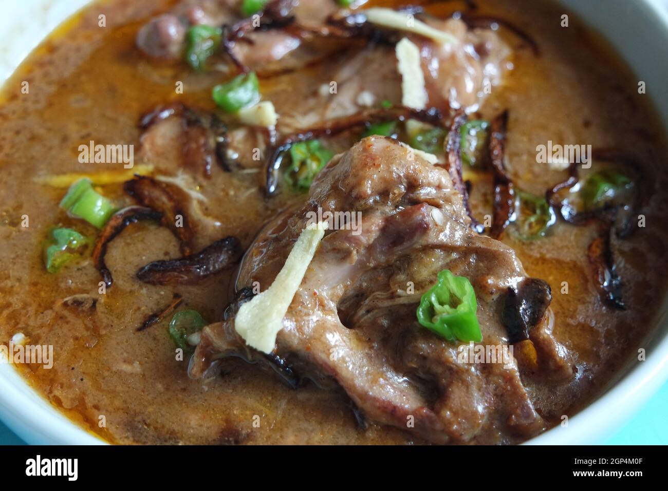 Vue rapprochée sur le plat traditionnel pakistanais de Haleem avec salade et jus de citron. Banque D'Images