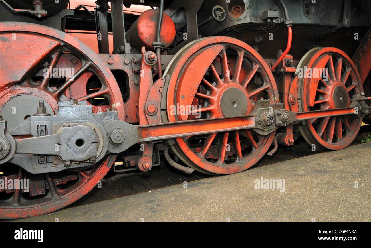 Vieilles roues de train rouges d'une vieille locomotive à vapeur dans le dépôt industriel et d'époque du chemin de fer Banque D'Images