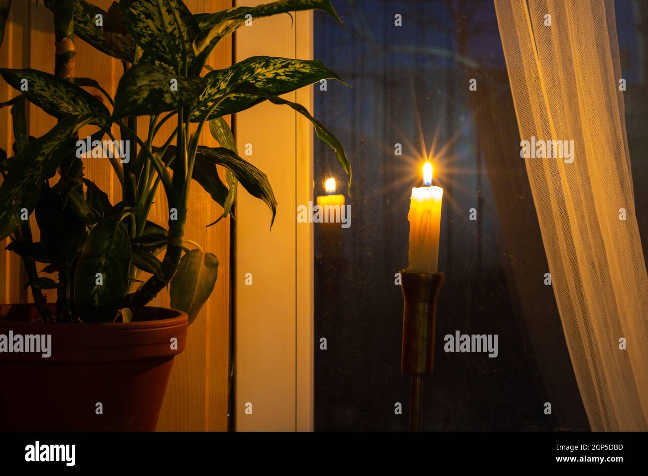 Une bougie solitaire se tient près de la fenêtre le soir comme un symbole de la mémoire de ceux qui sont morts dans guerres Banque D'Images