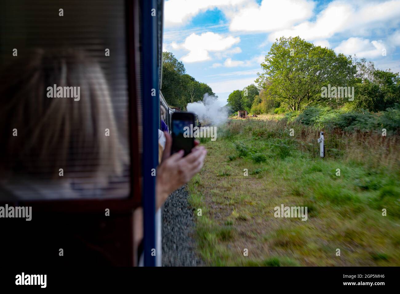 Une femme prenant une photo sur le chemin de fer à vapeur de la'al Ratty (Ravenglass & Eskdale) Banque D'Images