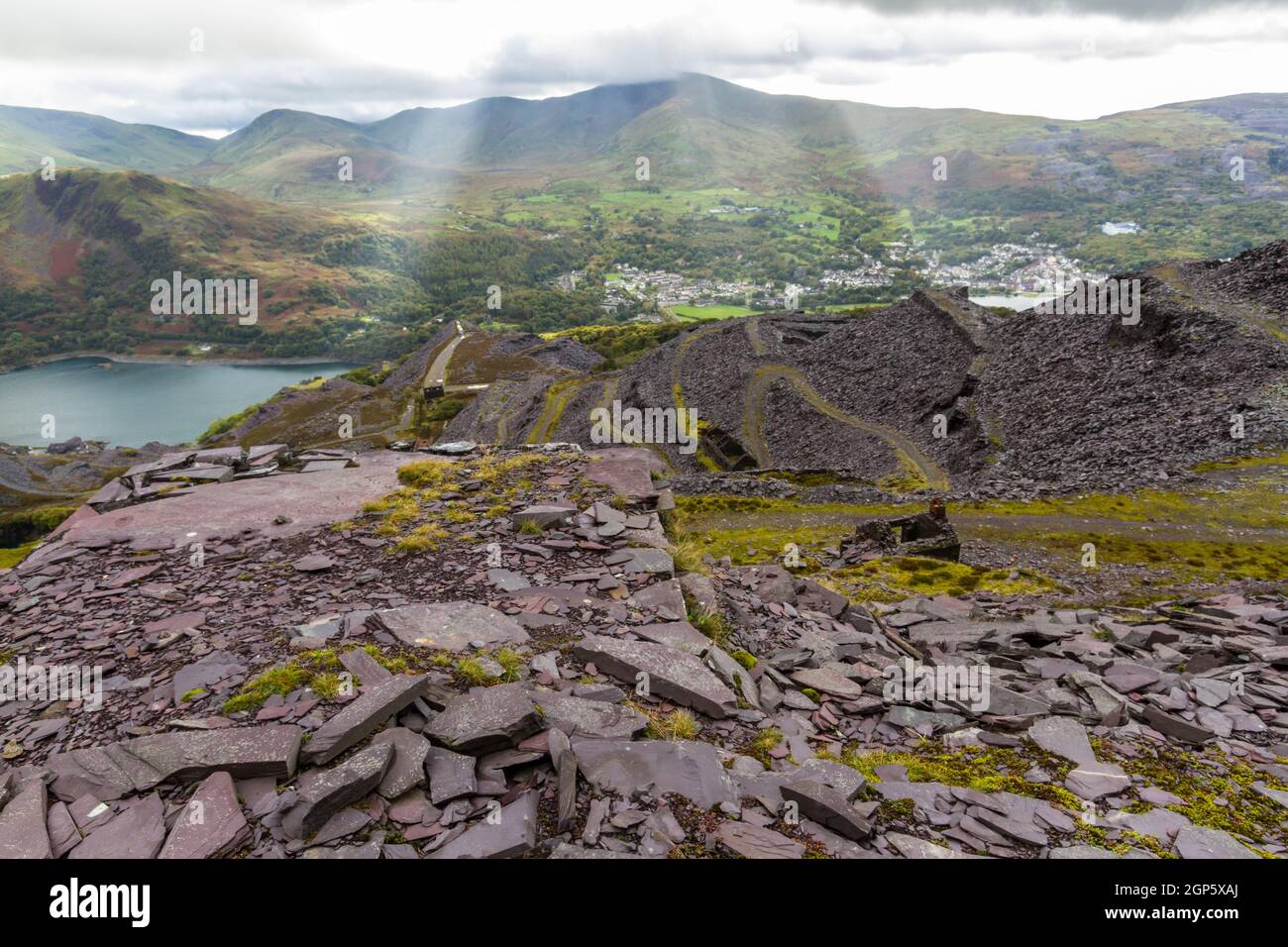 Vue depuis le sommet de la carrière de Slate de Dinorwic vers la ville de Llanberis, avec des rayons de soleil. Snowdonia, pays de Galles du Nord, Royaume-Uni. Patrimoine mondial de l'UNESCO. Paysage Banque D'Images