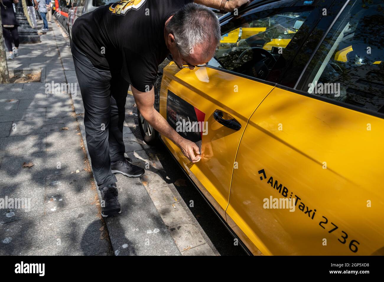 Barcelone, Espagne. 28 septembre 2021. Un chauffeur de taxi a vu déchirer le logo de FreeNow de son véhicule de taxi devant le siège de Free Now Barcelona sur la Plaza Catalunya.les chauffeurs de taxi ont participé à une marche lente contre les compagnies de transport avec des conducteurs Uber et Free Now, Qu'ils accusent de concurrence déloyale selon les règlements de l'Institut métropolitain de taxi. (Photo par Paco Freire/SOPA Images/Sipa USA) crédit: SIPA USA/Alay Live News Banque D'Images