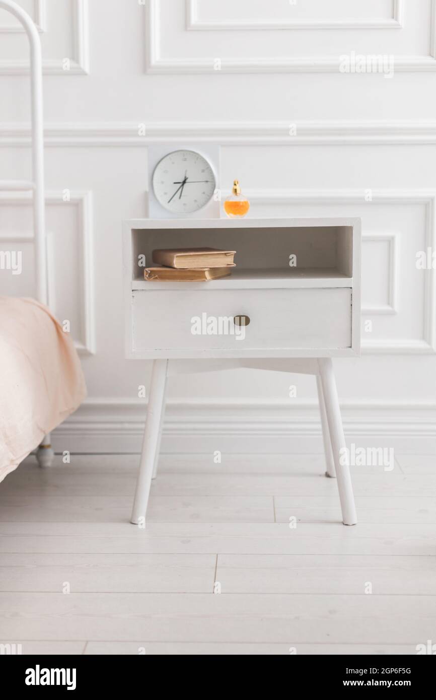 Table de nuit en bois blanc avec réveil et livres. Style scandinave Photo  Stock - Alamy