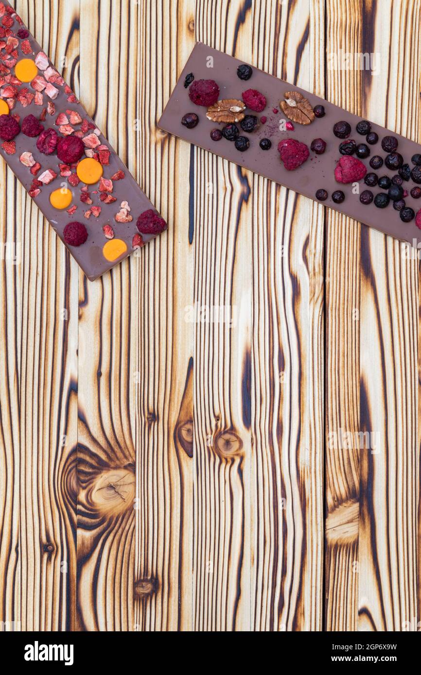 différents types de chocolat avec fruits séchés sur une planche en bois Banque D'Images