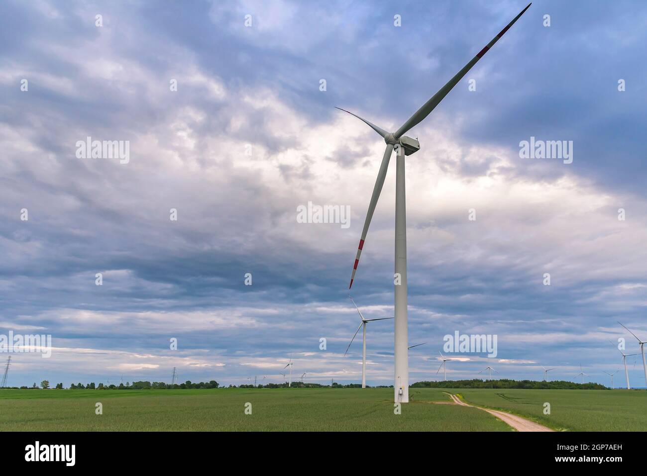 Éoliennes sur une ferme éolienne contre ciel nuageux à coucher de soleil Banque D'Images