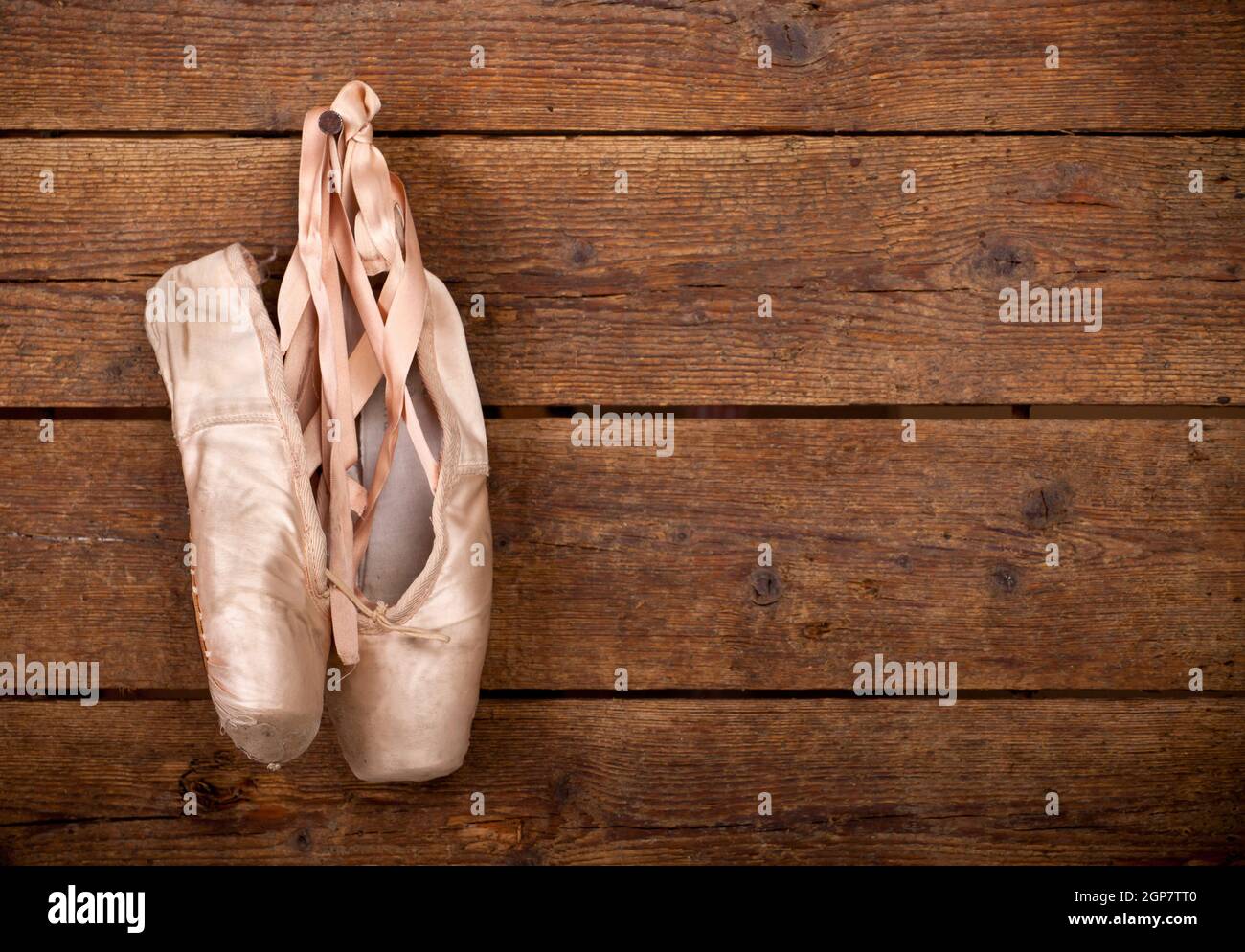 Chaussures de ballet rose vieille pendaison sur fond de bois Banque D'Images