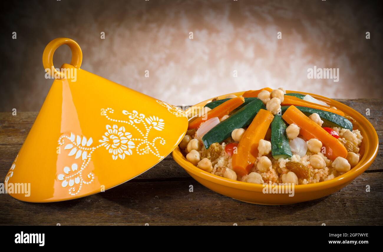 Tajine de légumes à couscous sur table en bois. Banque D'Images