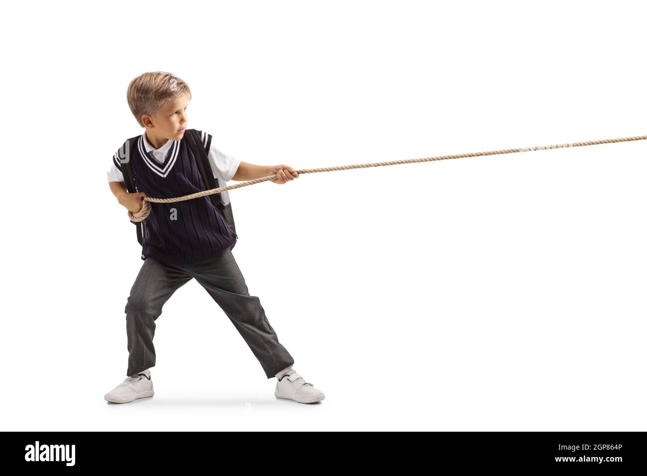 Photo pleine longueur d'un écolier en colère tirant une corde isolée sur fond blanc Banque D'Images