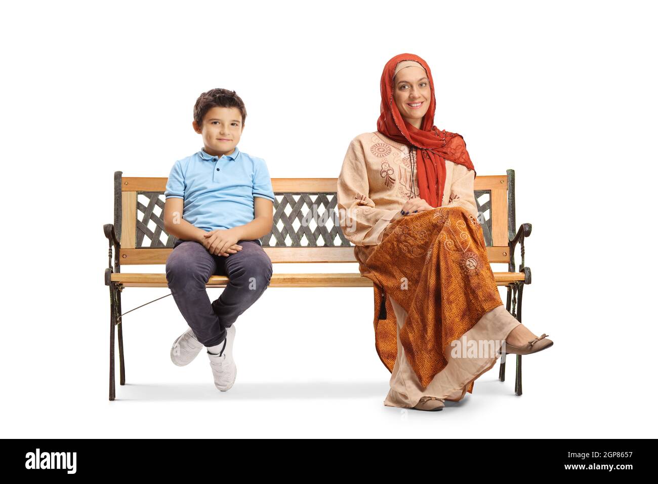 Jeune femme en vêtements ethniques assise sur un banc avec un petit garçon isolé sur fond blanc Banque D'Images