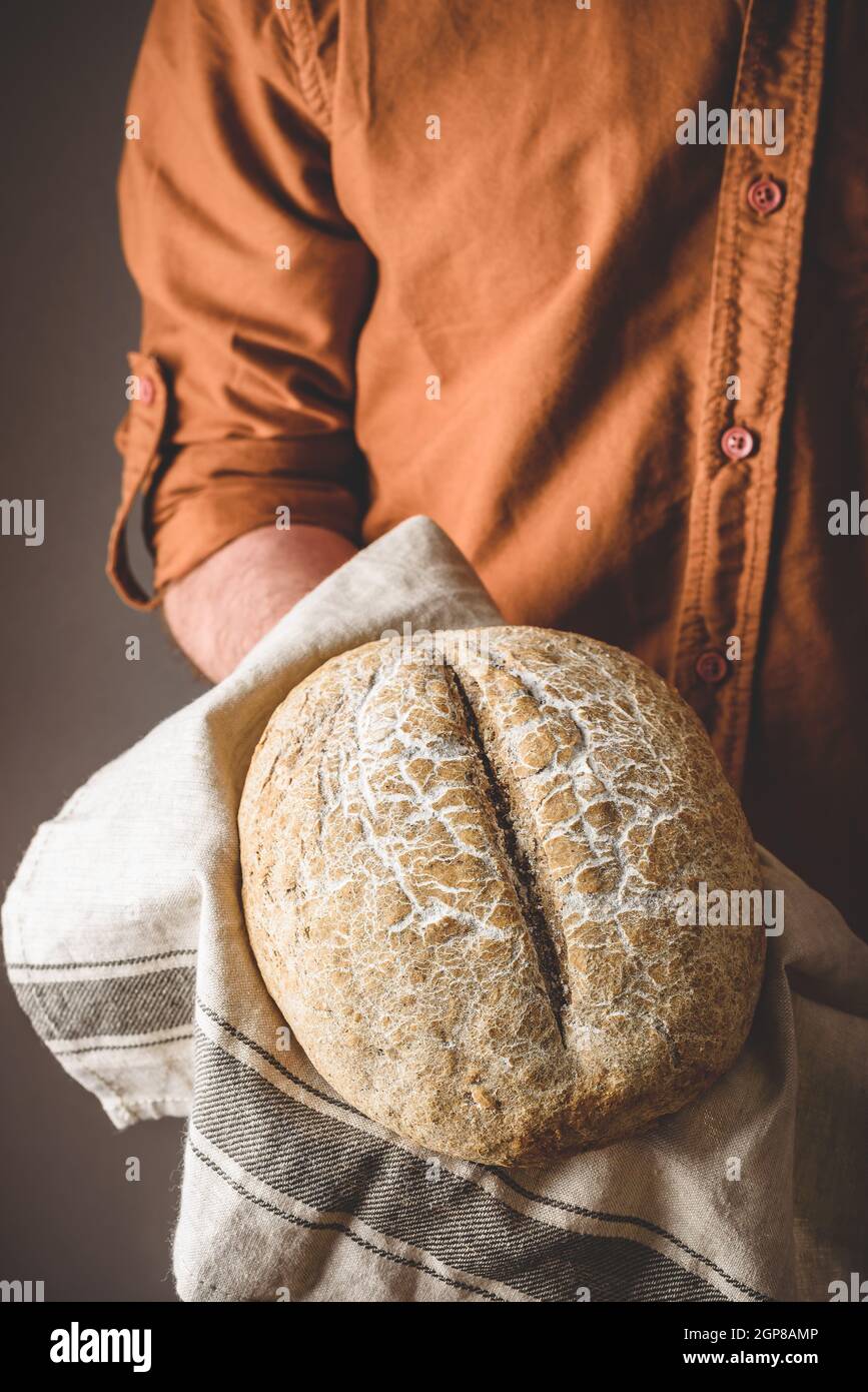 Baker tient un pain de seigle fraîchement cuit Banque D'Images
