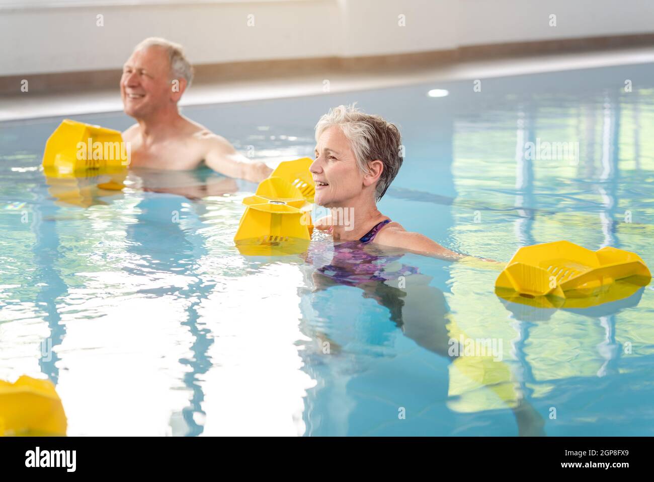 Les femmes et les hommes âgés en formation de réadaptation dans une classe de gymnastique aquatique Banque D'Images