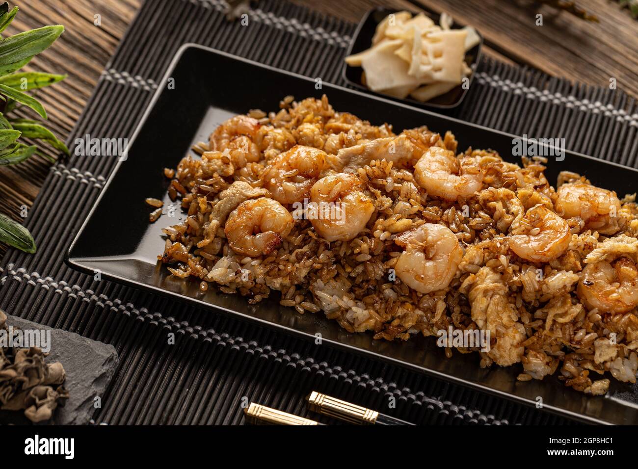 Riz frit aux crevettes classiques dans une assiette noire. Une alimentation thaïlandaise saine Banque D'Images