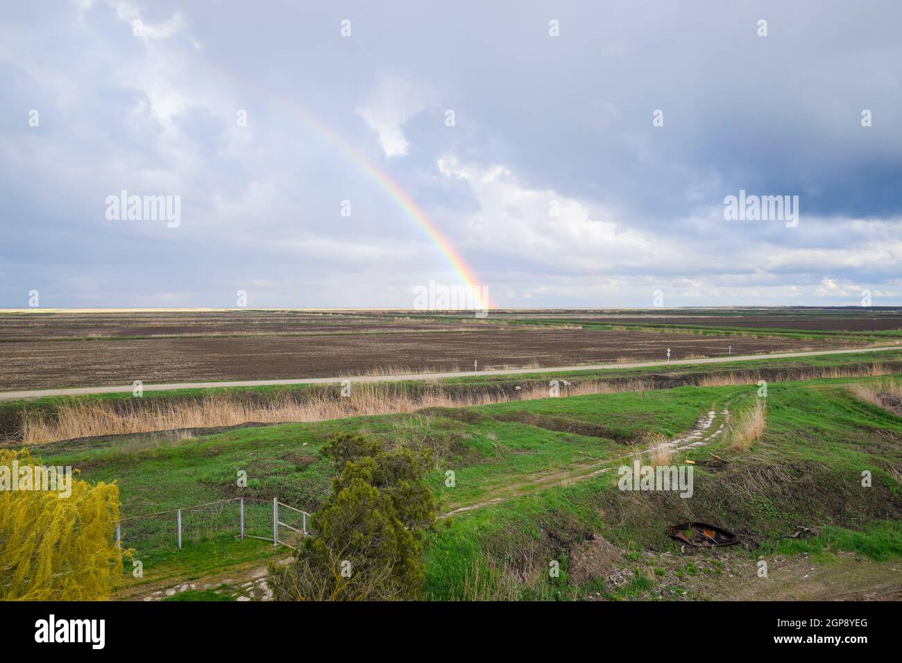 Arc-en-ciel, une vue sur le paysage dans le domaine. Formation de l'arc en ciel après la pluie. La réfraction de la lumière et de l'expansion en termes de spectres. Banque D'Images