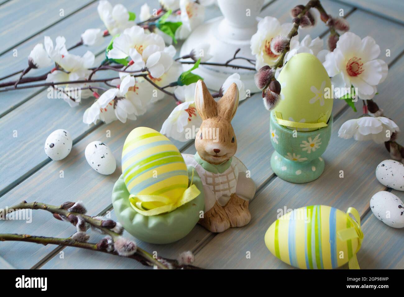 Décoration de Pâques avec lapin et œufs sur table en bois pastel Banque D'Images