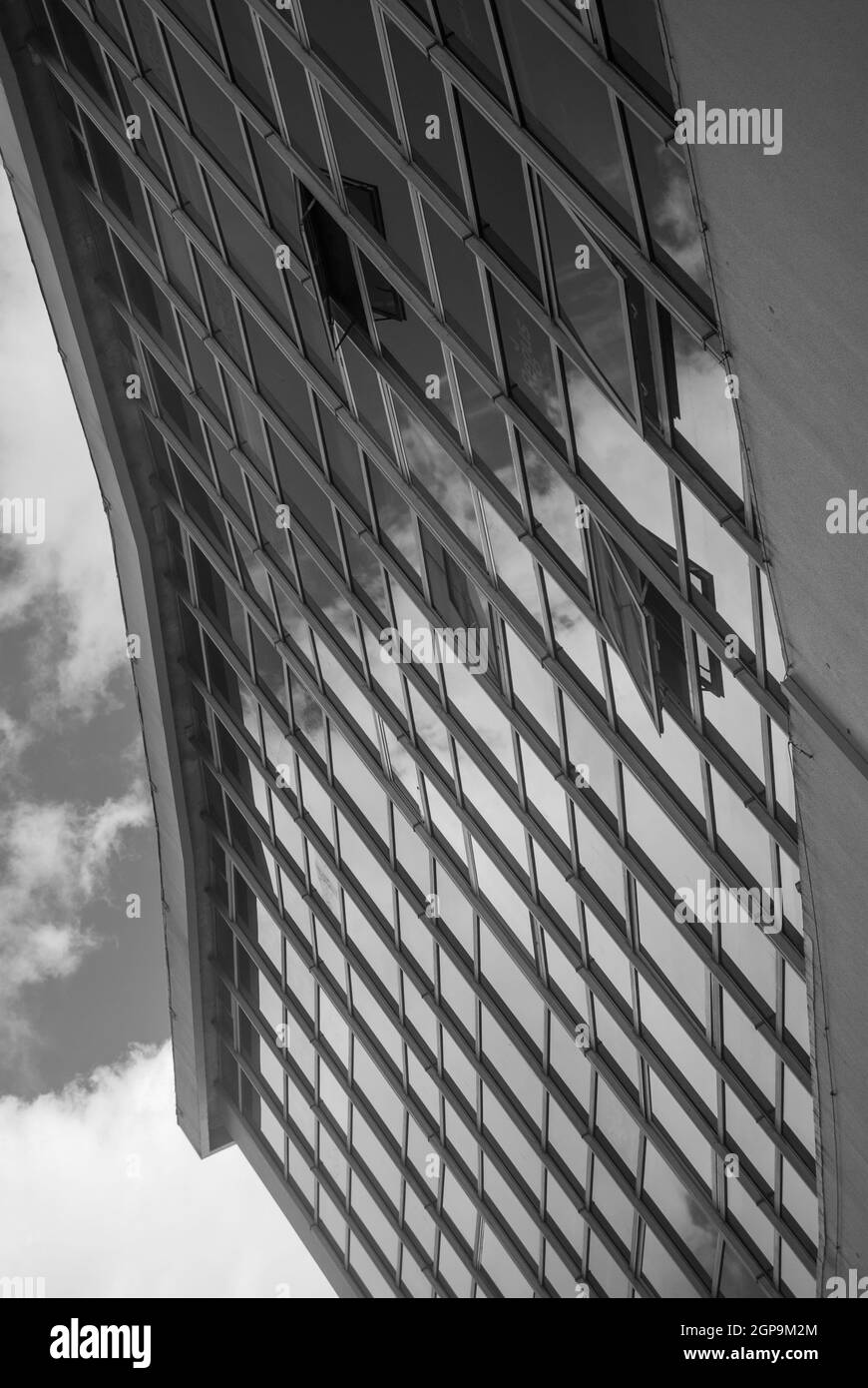 Architecture urbaine abstraite, reflet des nuages dans le ciel dans les fenêtres de l'édifice gratte-ciel couvert de verre, perspective brisée - Blac Banque D'Images